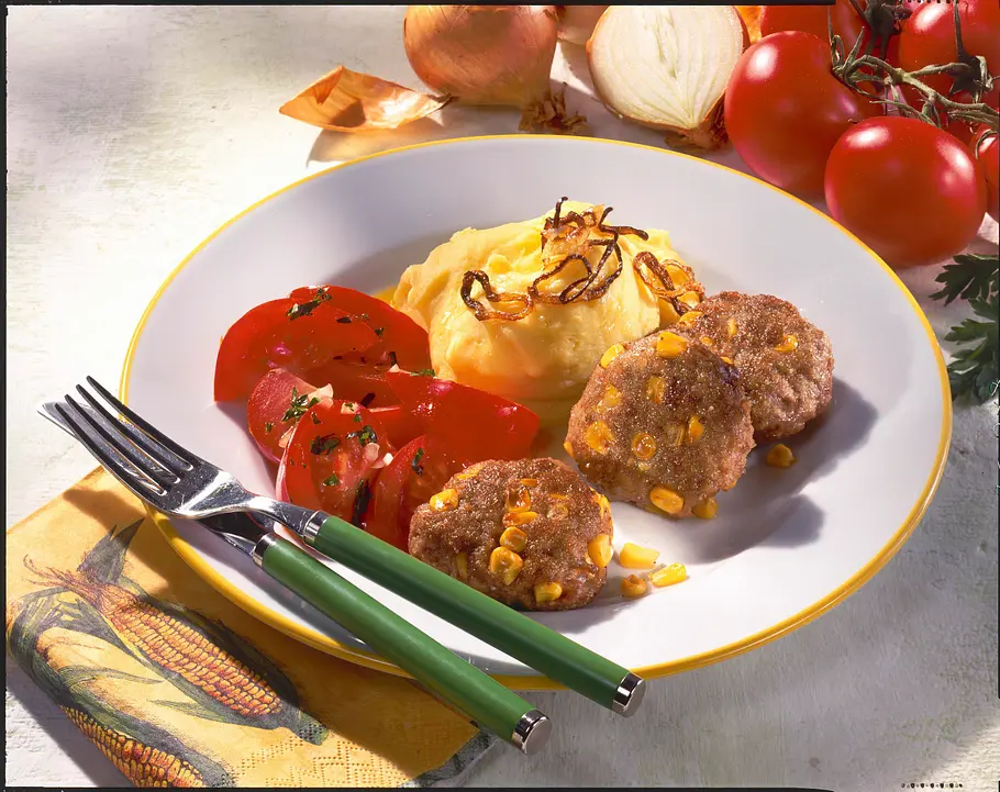 Mais-Frikadellen mit Kartoffelpüree, Zwiebelringen und Tomatensalat Rezept Mais-Frikadellen mit Kartoffelpüree, Zwiebelringen und Tomatensalat Rezept