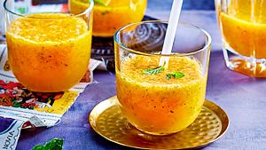 Mango Lemon Squash in Gläsern mit kurzen Strohhalmen und Minze serviert, auf einem goldenen Untersetzer. - Foto: House of Food / Bauer Food Experts KG