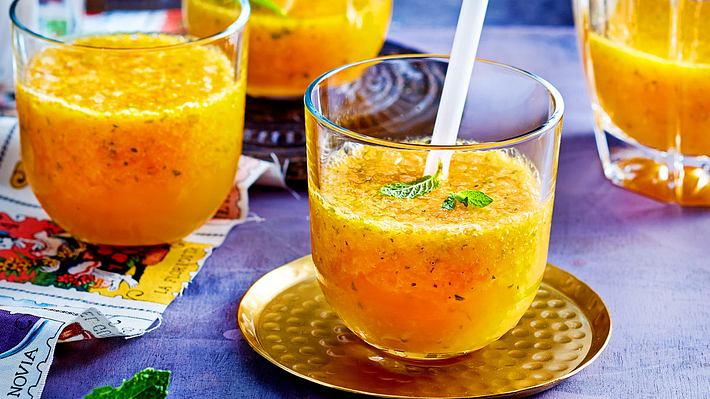 Mango Lemon Squash in Gläsern mit kurzen Strohhalmen und Minze serviert, auf einem goldenen Untersetzer. - Foto: House of Food / Bauer Food Experts KG