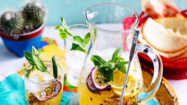 Eine Karafffe und ein Glas gefüllt mit Maracuja-Minz-Spritz auf einem bunten Tablett - Foto: House of Food / Bauer Food Experts KG