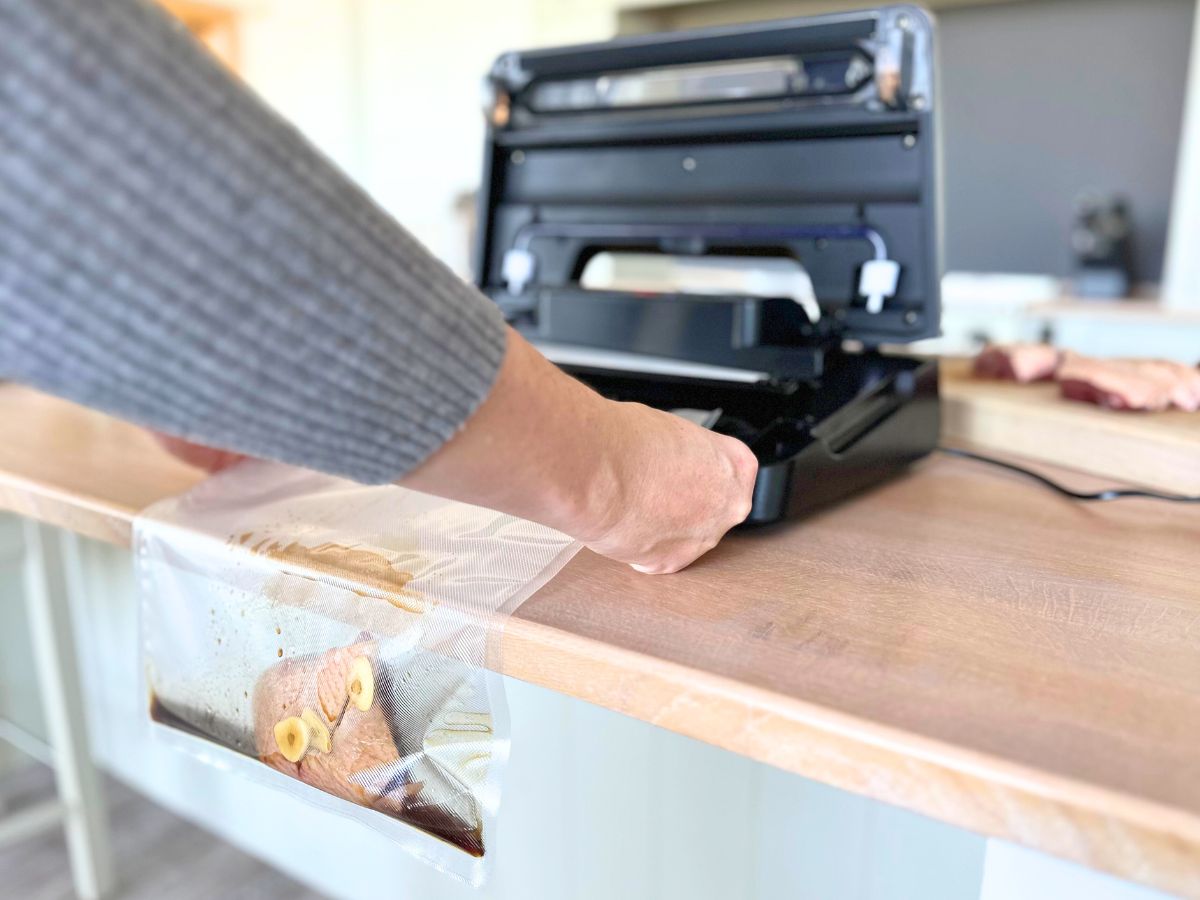 Mariniertes Fleisch hängt im Beutel über die Tischkante