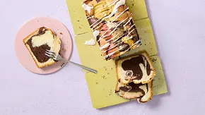 Saftiger Marmor-Apfelkuchen als Kastenkuchen mit dunkler und heller Teigschicht, Apfelstücken und Zuckerguss, in Scheiben geschnitten auf einem gelben Untergrund. - Foto: LECKER @ Bauer Media Group Saftiger Marmor-Apfelkuchen als Kastenkuchen mit dunkler und heller Teigschicht, Apfelstücken und Zuckerguss, in Scheiben geschnitten auf einem gelben Untergrund. - Foto: LECKER @ Bauer Media Group