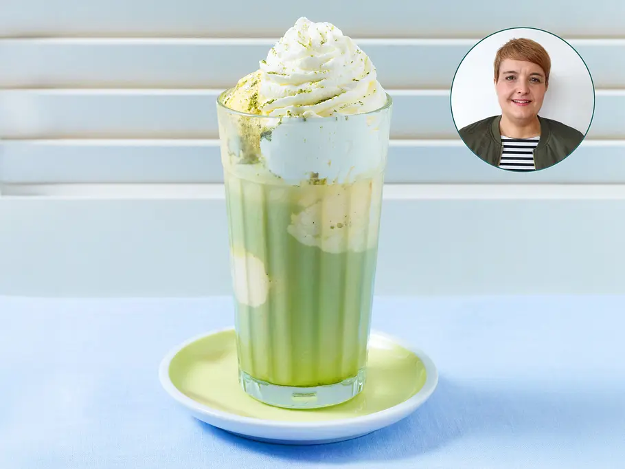 Matcha Latte mit Vanilleeis und Sahnehaube in einem großen Glas. Mit im Bild Redakteurin Birte.