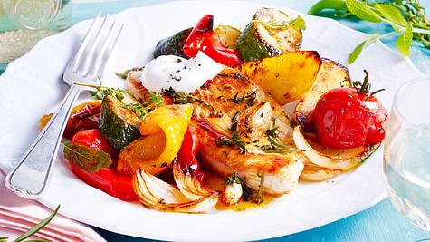 Mediterrane Putensteaks mit Ofengemüse mit einer Gabel auf einem Teller - Foto: House of Food / Bauer Food Experts KG