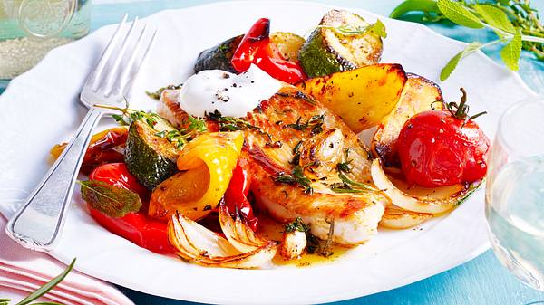 Mediterrane Putensteaks mit Ofengemüse mit einer Gabel auf einem Teller - Foto: House of Food / Bauer Food Experts KG