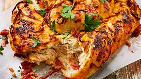 Mediterranes Grillbrot mit Kräutern, Tomaten und Petersilie auf Backpapier serviert, frisch angerissen. - Foto: LECKER @ Bauer Media Group Mediterranes Grillbrot mit Kräutern, Tomaten und Petersilie auf Backpapier serviert, frisch angerissen. - Foto: LECKER @ Bauer Media Group