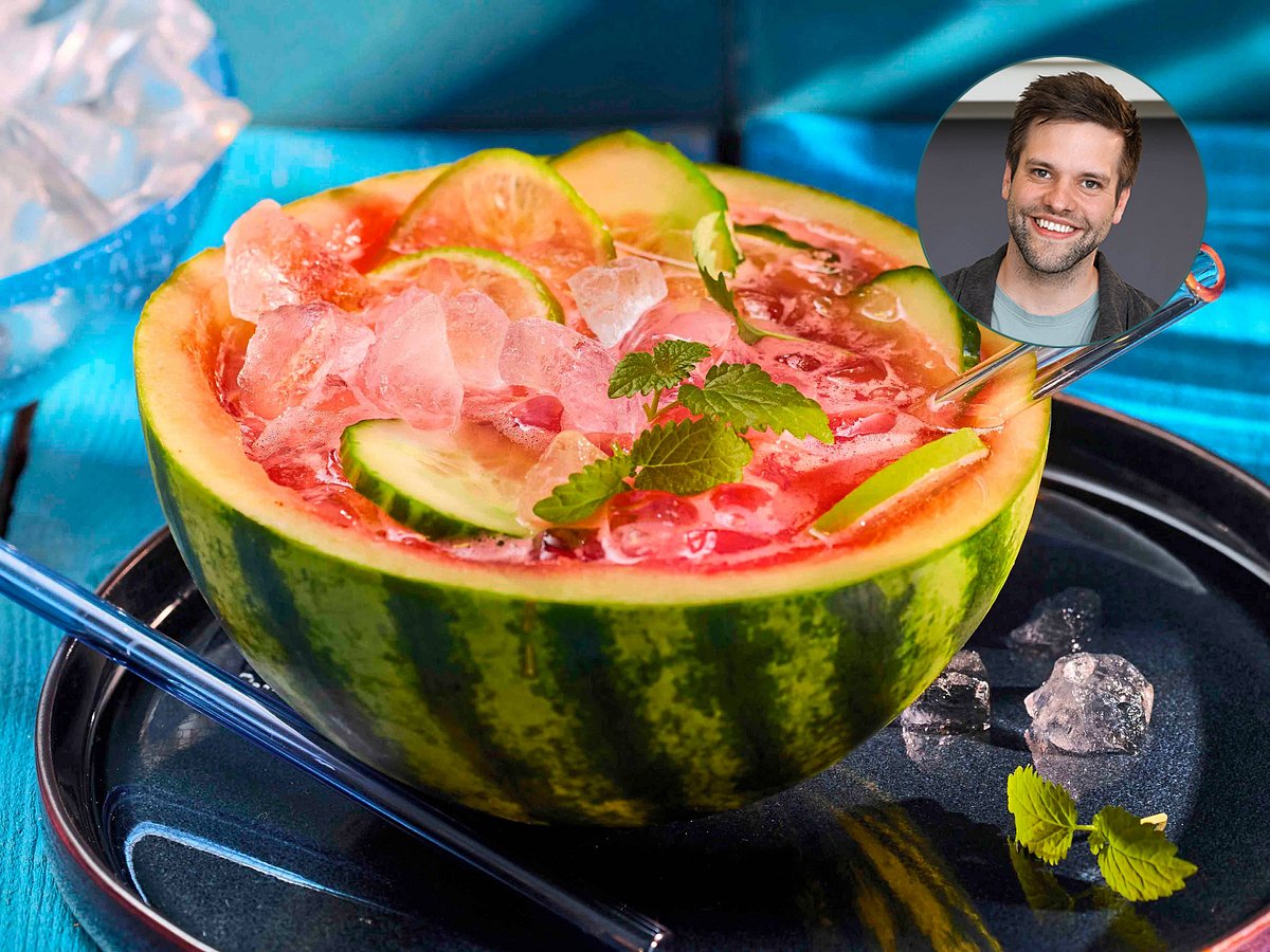 Wassermelonen-Limonade in einer ausgehöhlten Wassermelonen-Hälfte mit vielen Eiswürfeln und Gurkenscheiben-Deko. Mit im Bild: Redakteur Max.
