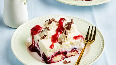 Ein Stück Milchreis-Tiramisu mit Beerensoße und Schokoraspel auf einem Teller. - Foto: LECKER @ Bauer Media Group Ein Stück Milchreis-Tiramisu mit Beerensoße und Schokoraspel auf einem Teller. - Foto: LECKER @ Bauer Media Group