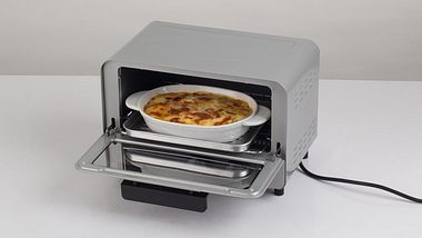 Geöffneter kleiner Ofen mit Lasagne - Foto: iStock/venusphoto