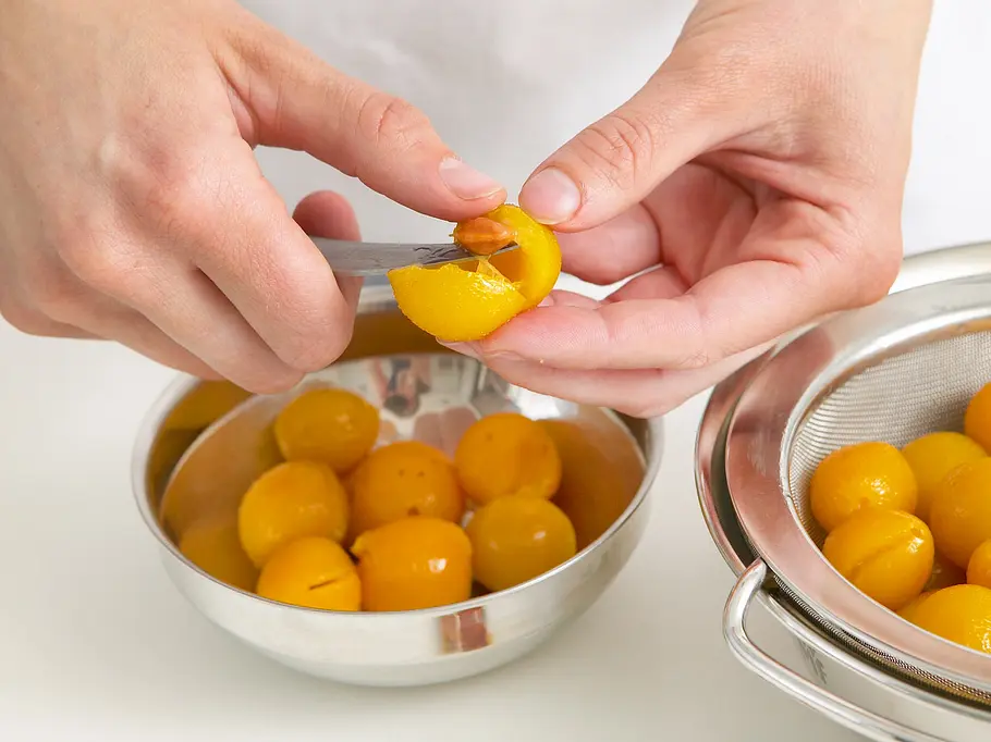 Eine Mirabelle wird mit einem kleinen Küchenmesser ensteint.