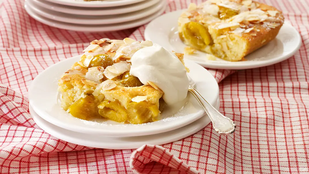 Mirabellenkuchen vom Blech auf einem weißen Teller mit einer Gabel und Sahne. - Foto: LECKER @ Bauer Media Group Mirabellenkuchen vom Blech auf einem weißen Teller mit einer Gabel und Sahne. - Foto: LECKER @ Bauer Media Group