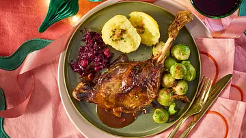 Saftige Gänsekeule mit glänzender Miso-Glasur und Bratensauce auf einem grünen Teller, dazu zwei Kartoffelklöße, Rotkohl und gebratener Rosenkohl auf rosa Stoffserviette. - Foto: LECKER @ Bauer Media Group Saftige Gänsekeule mit glänzender Miso-Glasur und Bratensauce auf einem grünen Teller, dazu zwei Kartoffelklöße, Rotkohl und gebratener Rosenkohl auf rosa Stoffserviette. - Foto: LECKER @ Bauer Media Group