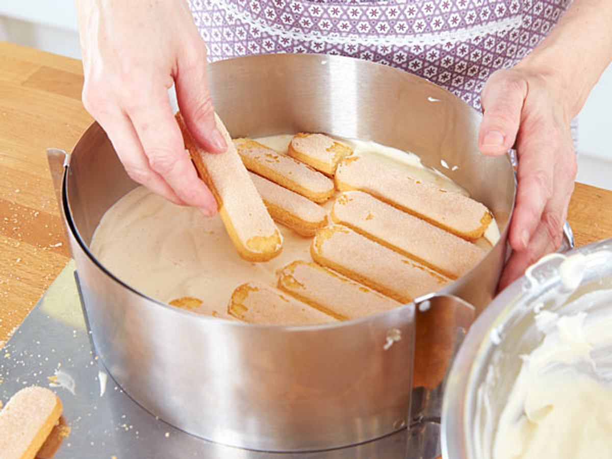 Malakoff-Torte in die Form schichten