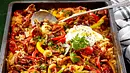 Ofenreisfleisch mit Reis, Paprika und Dip liegt zum Mittagessen auf einem Blech bereit. - Foto: LECKER @ Bauer Media Group
