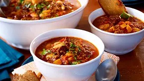 Drei Schalen mit würziger Mitternachtssuppe mit Gulasch, Hackfleisch, Bohnen und Petersilie, dazu Brot als Beilage. - Foto: LECKER @ Bauer Media Group Drei Schalen mit würziger Mitternachtssuppe mit Gulasch, Hackfleisch, Bohnen und Petersilie, dazu Brot als Beilage. - Foto: LECKER @ Bauer Media Group
