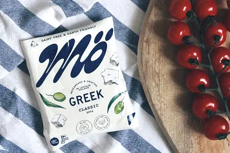 Mö Greek veganer Feta Mö Greek veganer Feta rechts ein paar Kirschtomaten am Stiel.