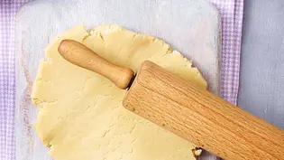 Mürbeteig liegt auf einem Brettchen, darauf ein Nudelholz. - Foto: House of Food / Bauer Food & Foto Experts KG Mürbeteig liegt auf einem Brettchen, darauf ein Nudelholz. - Foto: House of Food / Bauer Food & Foto Experts KG