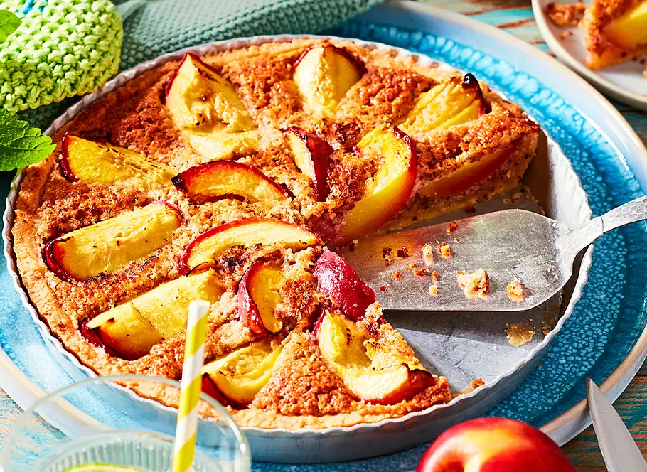 Nektarinen-Sommertarte Rezept Nektarinen-Sommertarte mit Mürbeteig, Vanillecreme und frischen Nektarinen auf einem rustikalen Kuchenteller