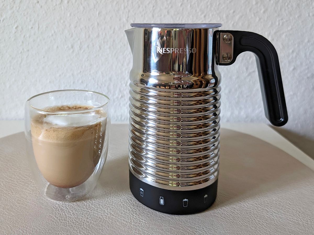 Der Nespresso Aeroccino 4 neben einem Glas Cappuccino