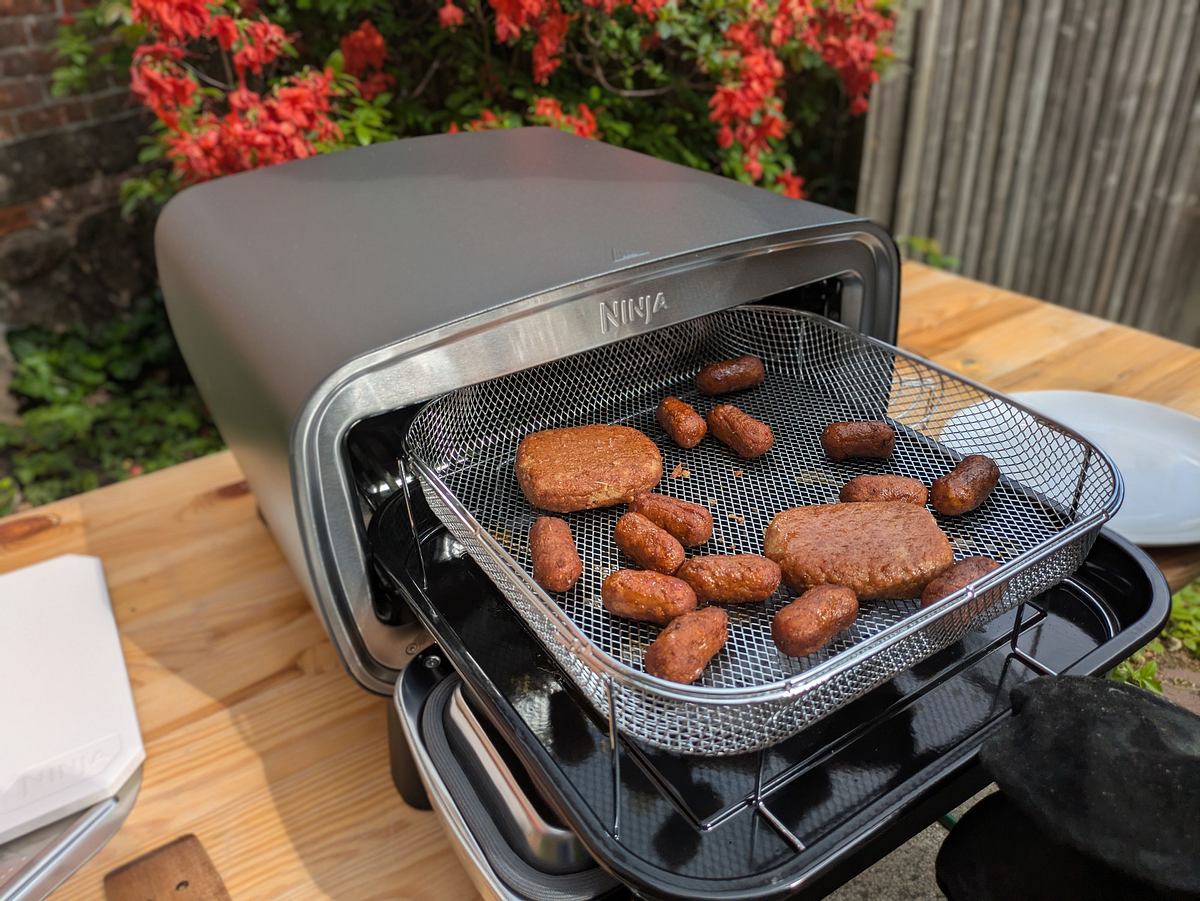 ninja-artisan-outdoor-elektro-pizzaofen-heissluftfritteuse Im Ninja Artisan Outdoor-Pizzaofen werden vegane Cevapcici und Bifteki in einem Heißluftkorb draußen knusprig gebacken.