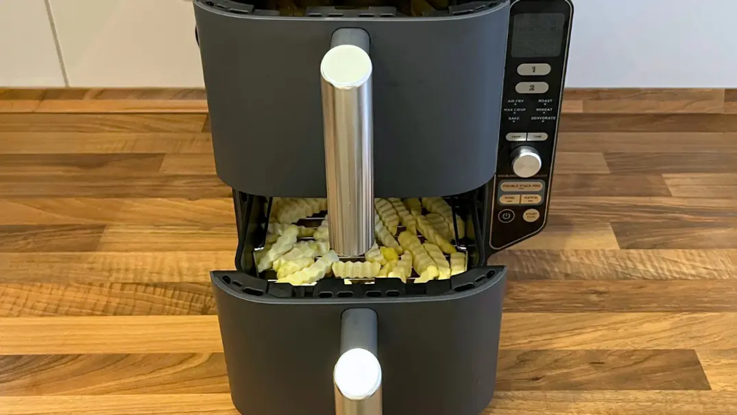 Der Ninja Double Stack XL Airfryer steht mit leicht geöffneten Schubladen auf einer hölzernen Küchenanrichte, sodass man sieh, dass beide Schubladen mit TK-Pommes gefüllt sind - Foto: LECKER @ Bauer Media Group / Franziska Hoppe Der Ninja Double Stack XL Airfryer steht mit leicht geöffneten Schubladen auf einer hölzernen Küchenanrichte, sodass man sieh, dass beide Schubladen mit TK-Pommes gefüllt sind - Foto: LECKER @ Bauer Media Group / Franziska Hoppe