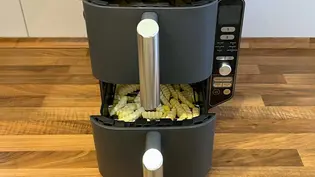 Der Ninja Double Stack XL Airfryer steht mit leicht geöffneten Schubladen auf einer hölzernen Küchenanrichte, sodass man sieh, dass beide Schubladen mit TK-Pommes gefüllt sind - Foto: LECKER @ Bauer Media Group / Franziska Hoppe