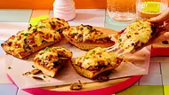 Ofen-Baguettes mit Pilzen und viel Käse liegen auf einem runden Holzbrett - Foto: LECKER @ Bauer Media Group