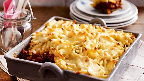 Ofen-Makkaroni mit Käse überbacken auf Bolognese in einer rechteckigen, grauen Auflaufform präsentiert. - Foto: LECKER @ Bauer Media Group