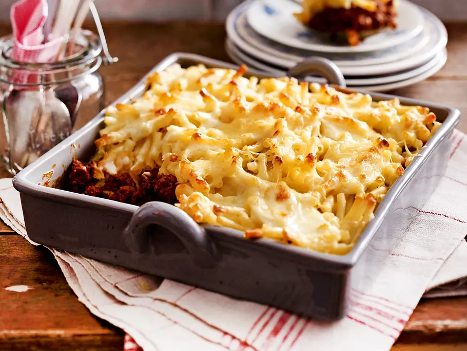 Ofen-Makkaroni Rezept Ofen-Makkaroni mit Käse überbacken auf Bolognese in einer rechteckigen, grauen Auflaufform präsentiert.