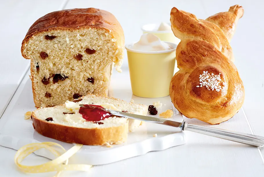 Osterklöben mit Rosinen ist angeschnitten, daneben ein Brötchen im Hasen-Look.