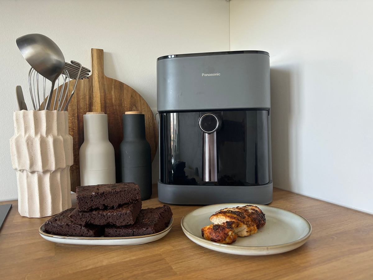 Der Panasonic Airfryer auf einer Küchenzeile, davor Brownies und Hähnchenbrust