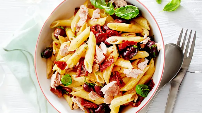 Penne Pomodoro e Tonno in einer weißen Schale daneben ein Esslöffel und eine Gabel - Foto: LECKER @ Bauer Media Group Penne Pomodoro e Tonno in einer weißen Schale daneben ein Esslöffel und eine Gabel - Foto: LECKER @ Bauer Media Group