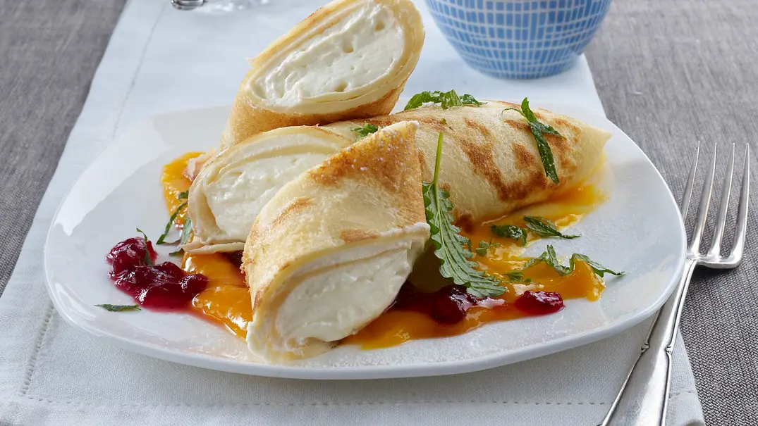 Pfannkuchenröllchen mit Vanillequark auf Mangopüree mit Preiselbeeren Rezept - Foto: LECKER @ Bauer Media Group