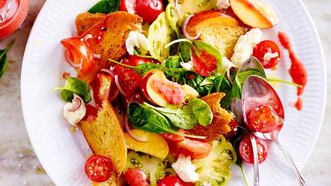 Pfirsich-Tomaten-Brotsalat mit Himbeer-Vinaigrette auf einem weißen Teller mit Besteck - Foto: House of Food / Bauer Food Experts KG