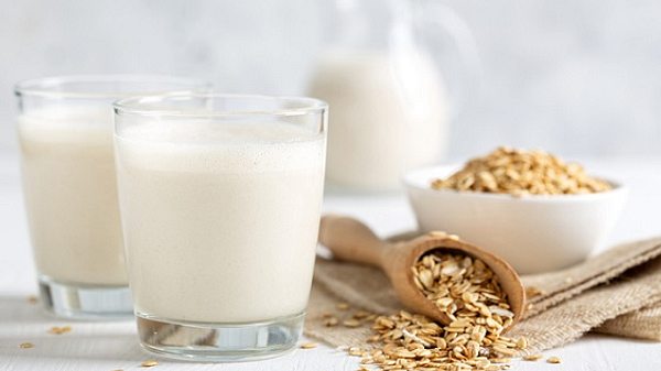 Pflanzenmilch im Glas neben Haferflocken - Foto: iStock/YelenaYemchuk