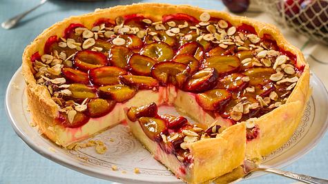 Pflaumen-Schmand-Kuchen auf einer Tortenplatte, angeschnitten. Ein Stück auf Tortenheber - Foto: LECKER @ Bauer Media Group