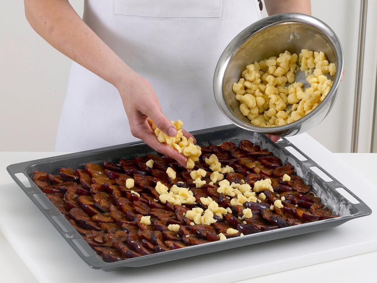 Pflaumenkuchen vom Blech mit Streuseln bestreuen