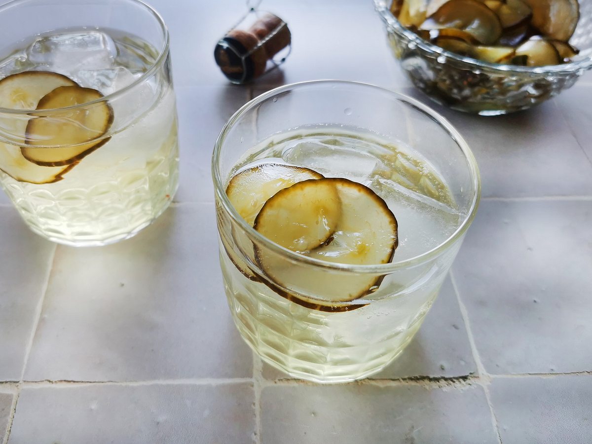 Pickle Spritz mit Prosecco, eingelegten Gurkenscheiben und Eiswürfeln in zwei Gläsern