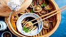 Gedämpfte Pilz-Dim-Sum in einem Bambus-Dämpfer und Essstäbchen, die eine der Teigtaschen in ein Schächen mit Sojasoße tunken. - Foto: LECKER @ Bauer Media Group Gedämpfte Pilz-Dim-Sum in einem Bambus-Dämpfer und Essstäbchen, die eine der Teigtaschen in ein Schächen mit Sojasoße tunken. - Foto: LECKER @ Bauer Media Group