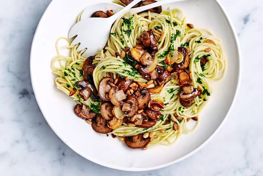Pilz-Spaghetti auf einem weißen Teller serviert.