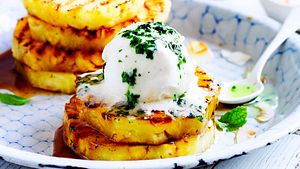 Pina Colada on fire: Gegrillte Ananasscheiben mit Kokoseis auf einem Teller serviert - Foto: House of Food / Bauer Food Experts