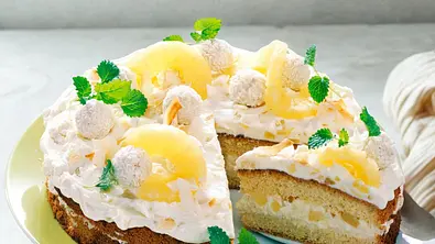 Angeschnittene Piña-Colada-Torte auf einem grünen Teller. - Foto: LECKER @ Bauer Media Group