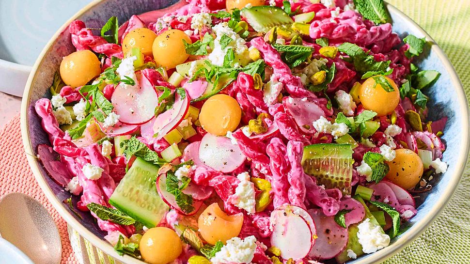 Bunter Nudelsalat mit pinken Nudeln, Gurken, Radieschen und Melonenkugeln in einer großen Salatschüssel. - Foto: House of Food / Bauer Food Experts KG 