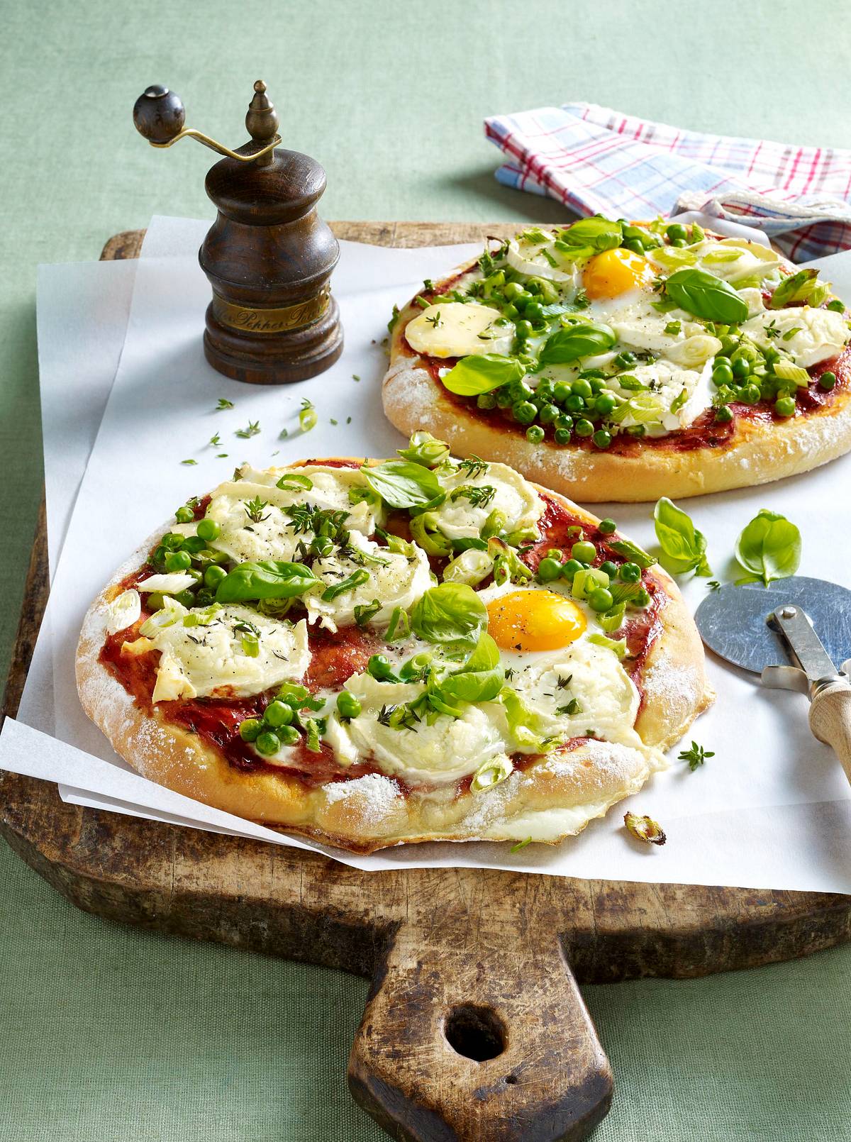 Pizza mit Tomatensugo, Erbsen, Lauchzwiebeln, Ziegenkäse und Spiegelei Rezept