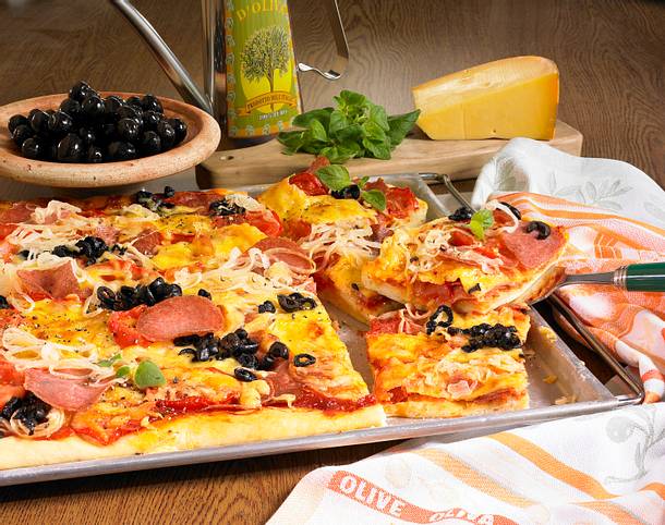 Pizza vom Blech mit Salami, Gemüsezwiebeln, frischen Tomaten und Oliven ...