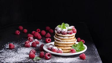 Ein Teller voll Pancakes steht auf einem Platzteller aus Schiefer - Foto: iStock/white_caty