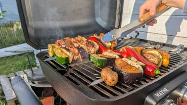Grillspieße werden mithilfe einer Grillzange gewendet. - Foto: LECKER @ Bauer Media Group / Emily Beckmann Grillspieße werden mithilfe einer Grillzange gewendet. - Foto: LECKER @ Bauer Media Group / Emily Beckmann