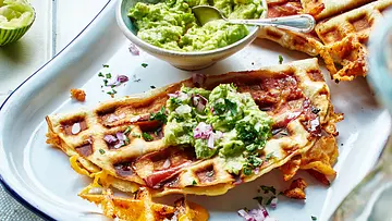 Knusprig gebackene Quesadillas mit geschmolzenem Käse und Speck, serviert mit Guacamole und gehackten roten Zwiebeln auf einem Teller. - Foto: LECKER @ Bauer Media Group Knusprig gebackene Quesadillas mit geschmolzenem Käse und Speck, serviert mit Guacamole und gehackten roten Zwiebeln auf einem Teller. - Foto: LECKER @ Bauer Media Group