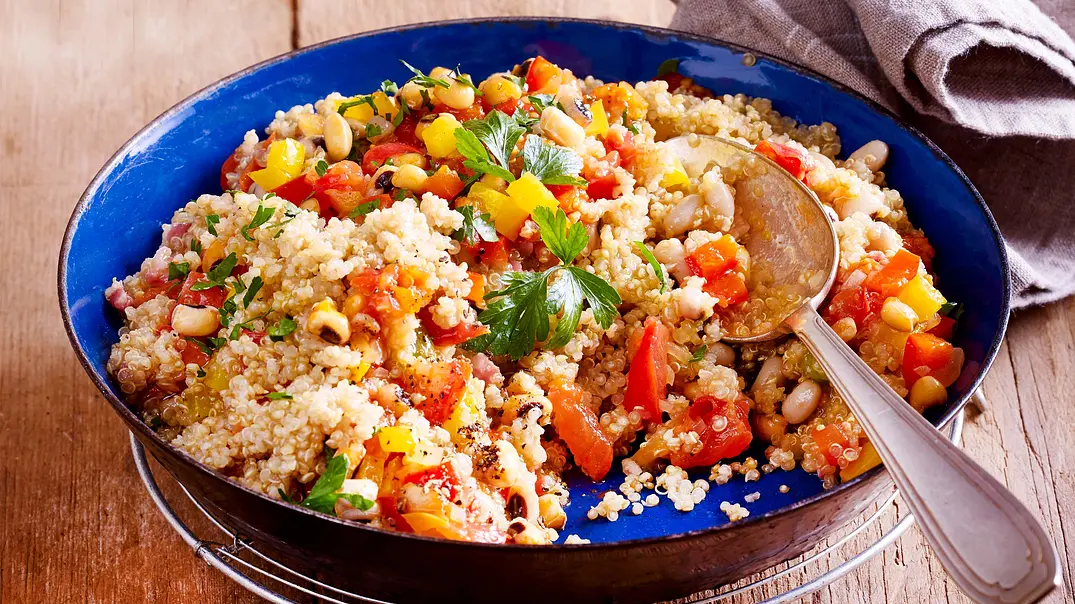 Quinoa-Gemüse-Pfanne in einer blauen Emaillepfanne mit Esslöffel darin - Foto: LECKER @ Bauer Media Group Quinoa-Gemüse-Pfanne in einer blauen Emaillepfanne mit Esslöffel darin - Foto: LECKER @ Bauer Media Group