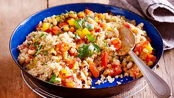 Quinoa-Gemüse-Pfanne in einer blauen Emaillepfanne mit Esslöffel darin - Foto: LECKER @ Bauer Media Group Quinoa-Gemüse-Pfanne in einer blauen Emaillepfanne mit Esslöffel darin - Foto: LECKER @ Bauer Media Group